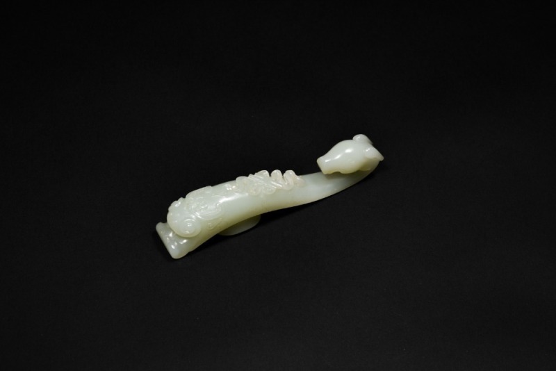 A Celadon-White Jade &lsquo;Ram-Head&rsquo; Belt Hook with Eight Treasures Design, Qing Dynasty, 18th&ndash;19th Century