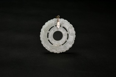 A Chinese Celadon Jade Openwork &lsquo;Ruyi&rsquo; Disc Pendant. Qing Dynasty.