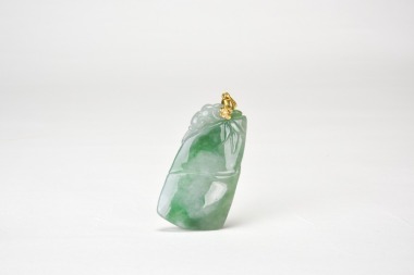 A Jadeite &lsquo;Bat and Bamboo&rsquo; Pendant with an 18K Gold Mount (G750).