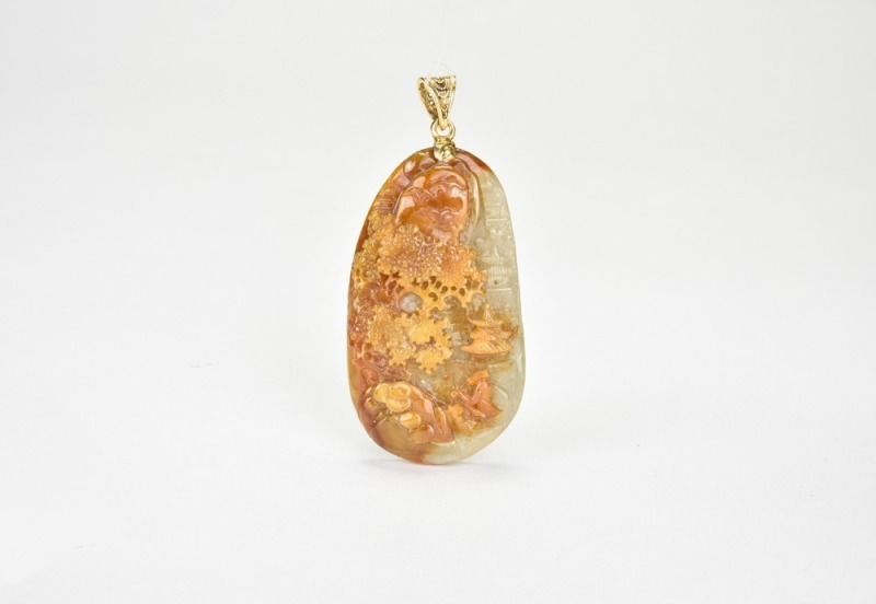 A Carved Jadeite Landscape Pendant with Russet Inclusions