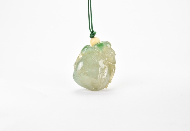 A Carved Jadeite &lsquo;Monkey and Pomegranate&rsquo; Pendant