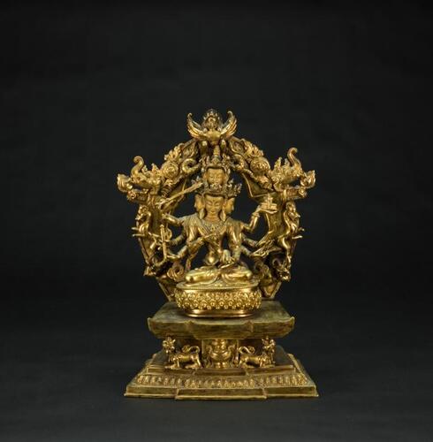 A Gilt- Bronzed Eight Arm Seated Guanyin